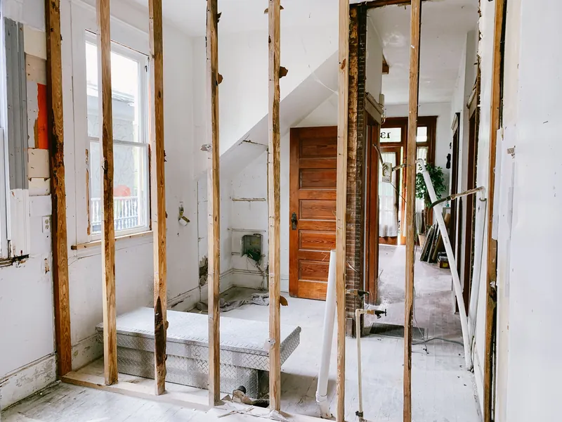 Et rom i et hus under renovering, med veggene revet ned til stenderne