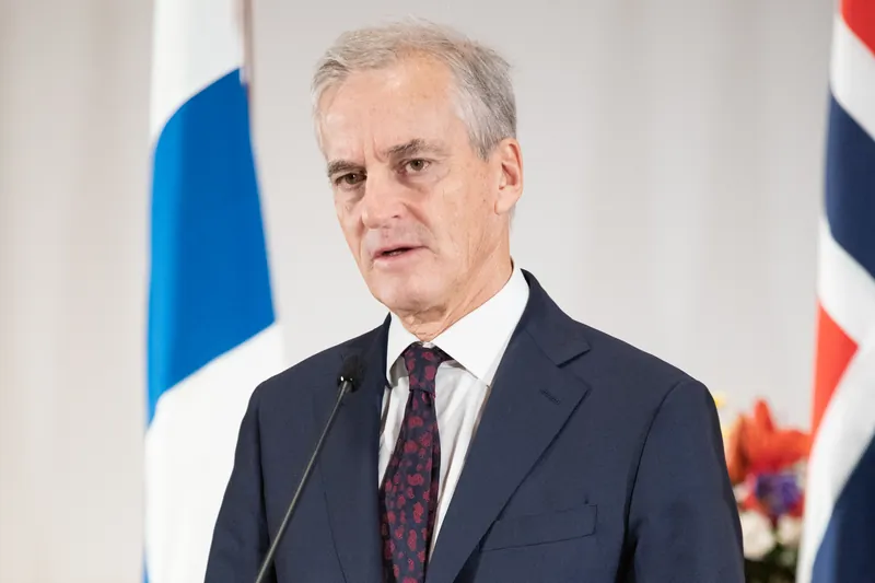 Statsminister Jonas Gahr Støre på en talerstol, med det finske og det norske flagget bak seg