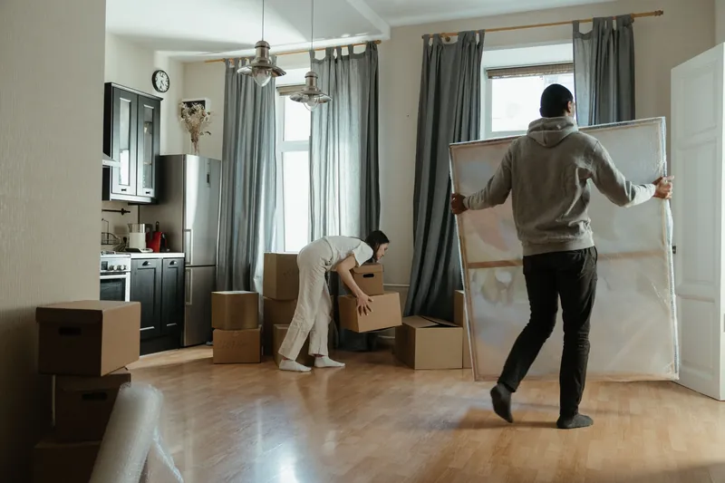 Et par pakker ut flytteesker i en lys leilighet